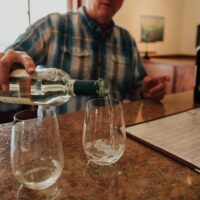 White wine being poured into a stemless wine glass in a tasting room