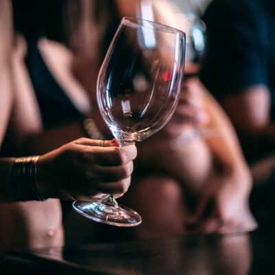 hand holding an empty wine glass