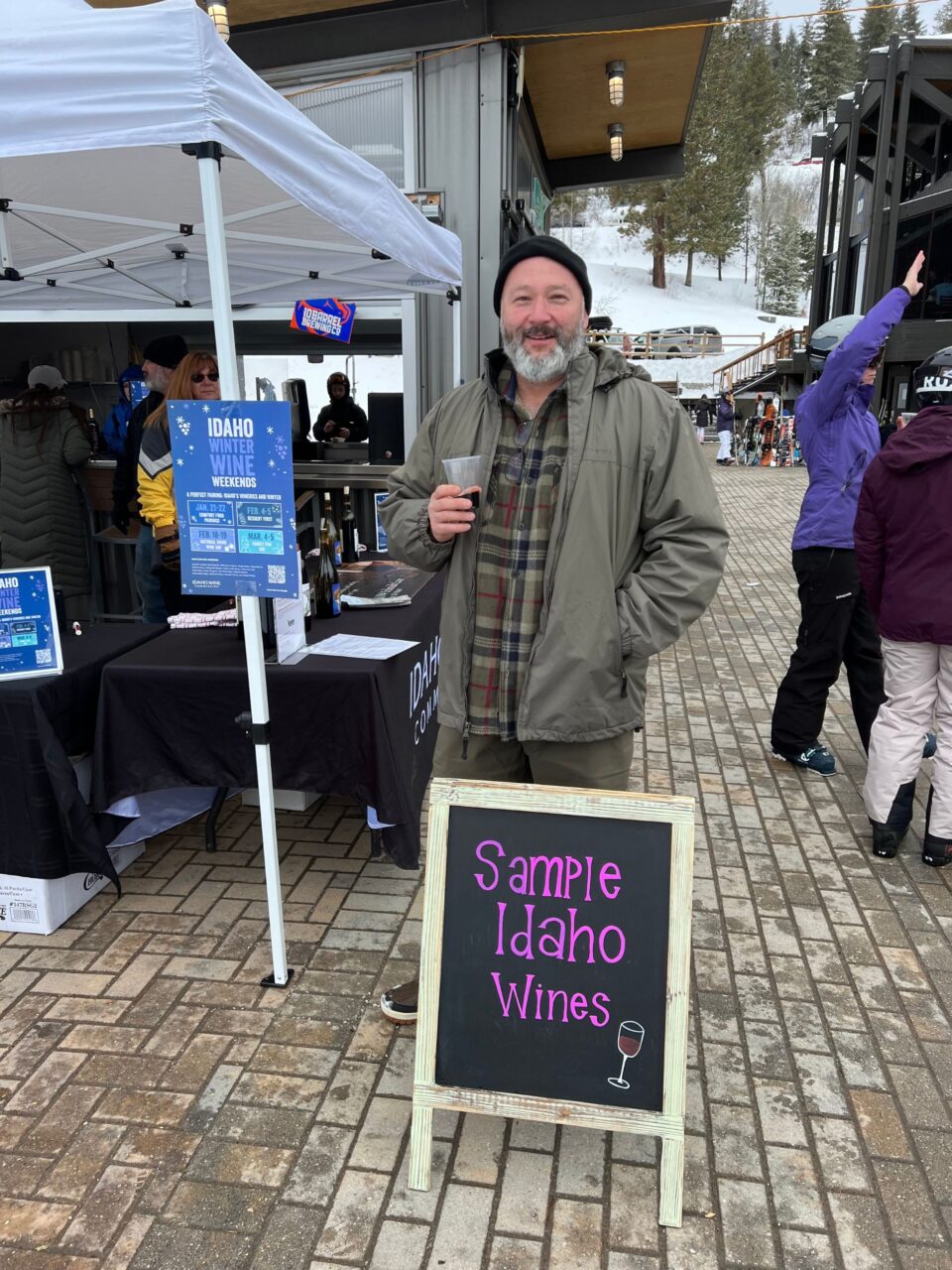 man standing outside at a sampling stand for a winery