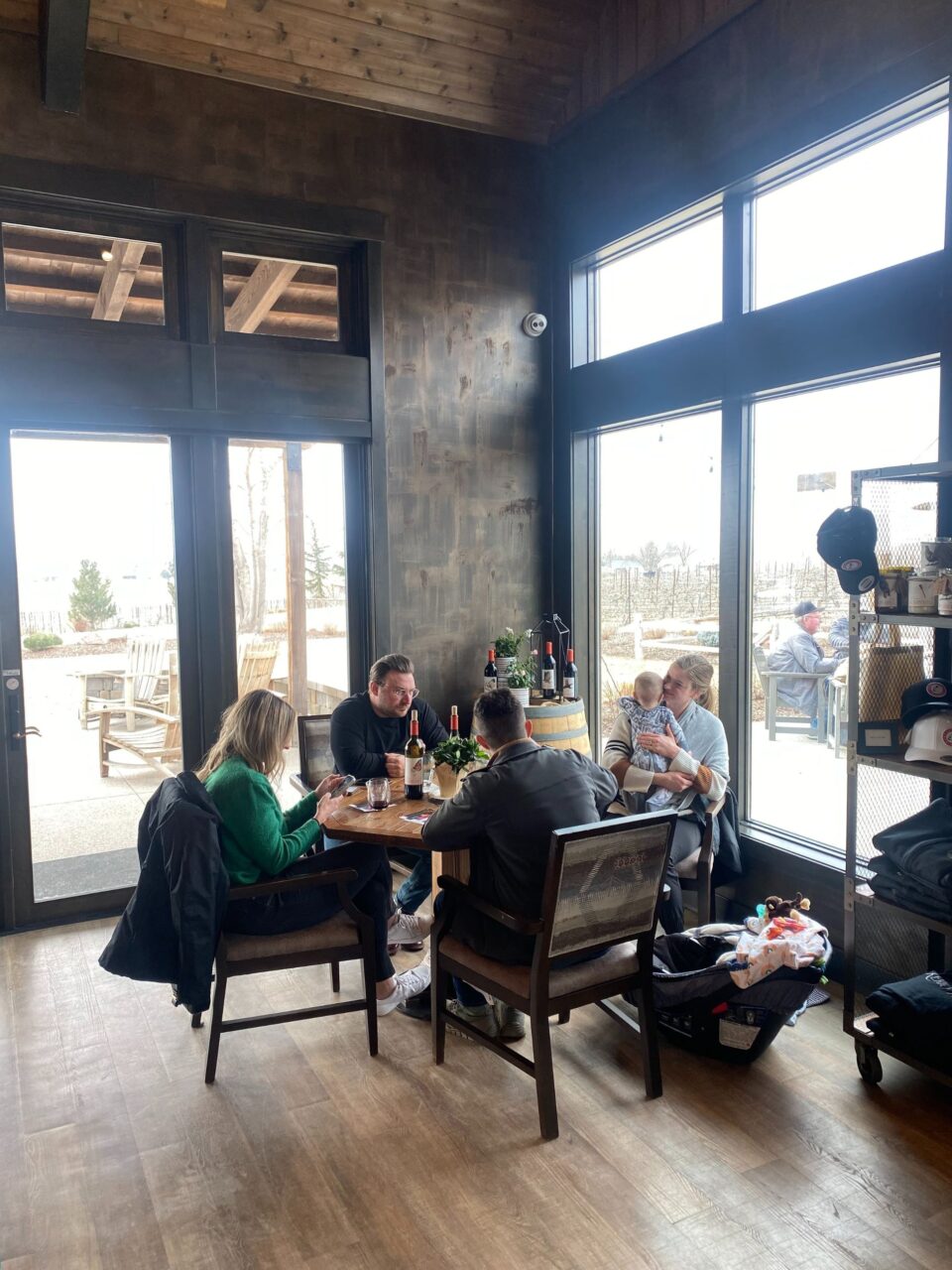 several people sitting around a table at a winery 